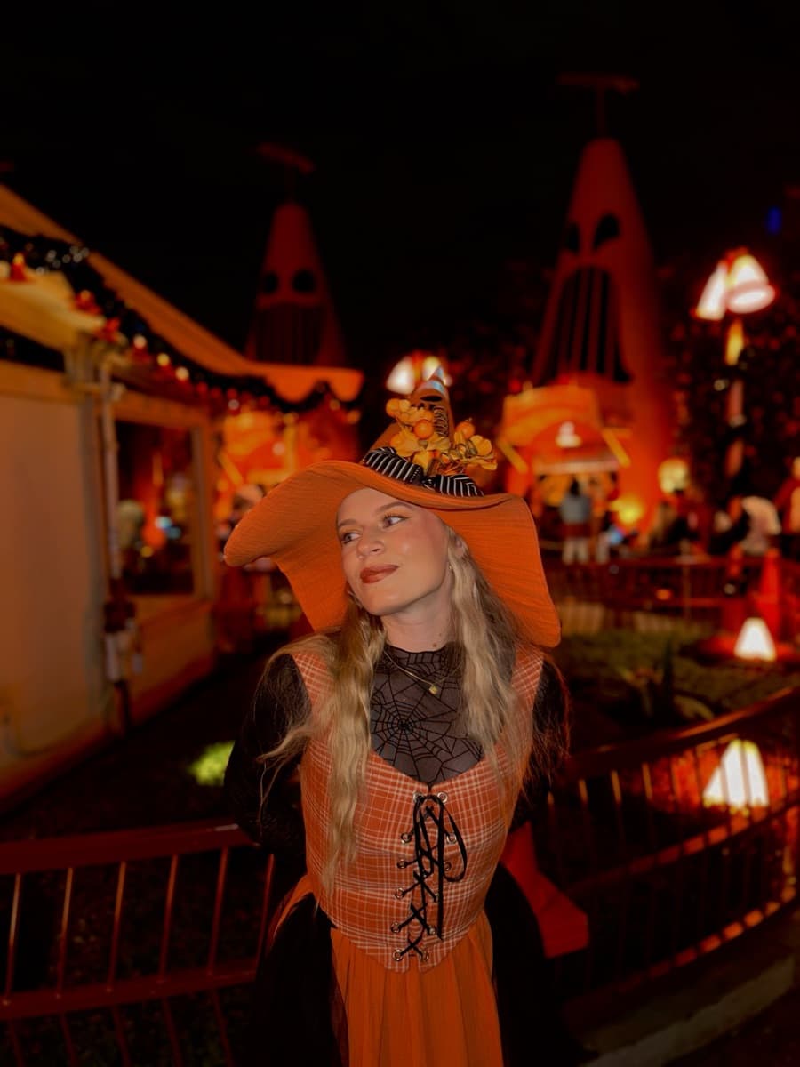 Kayla in an orange witch costume at night during the Oogie Boogie Bash