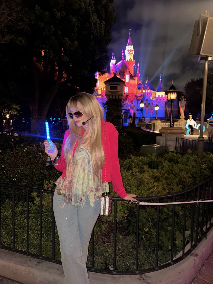 Kayla dressed as Hannah Montana in front of Sleeping Beauty Castle during Disney Channel Nite