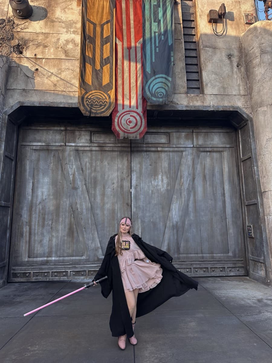 Kayla with a pink lightsaber in Star Wars: Galaxy's Edge during Star Wars Nite
